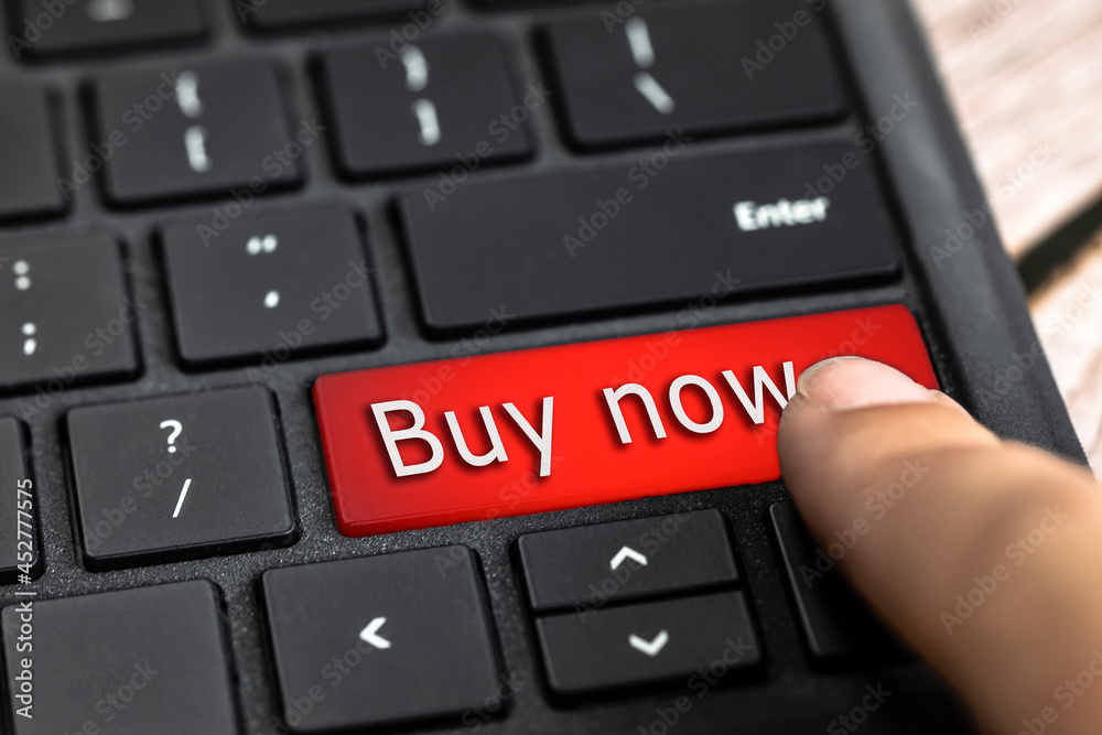 Closeup of finger on red computer keyboard key with the text Buy now in white Letters, Online shopping, technology and sale concept Closeup of finger on red computer keyboard key with the text Buy now in white Letters, Online shopping, technology and sale concept