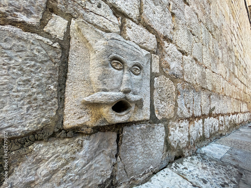 Closeup of a maskeron in Dubrovnik, Croatia. Maskerons drain rain water as well as believed to scare away evil spirits. photo