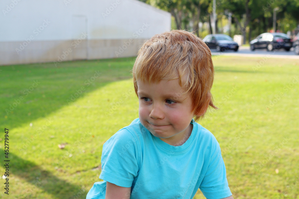 The blond boy looks to the side pursing his lips. Pensive four-year-old boy. The blond boy looks to the side pursing his lips. Pensive four-year-old boy.