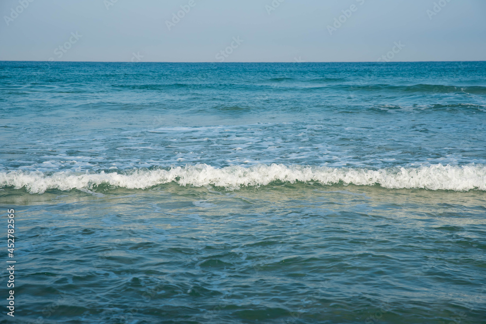 Sea or ocean tropical landscape view. Sea waves under the sun. Summer vacation and travel concept. Water wave surface. Sand beach. 