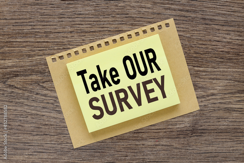 Take Our Survey, text on a wooden table, on a bright sticker Take Our Survey, text on a wooden table, on a bright sticker