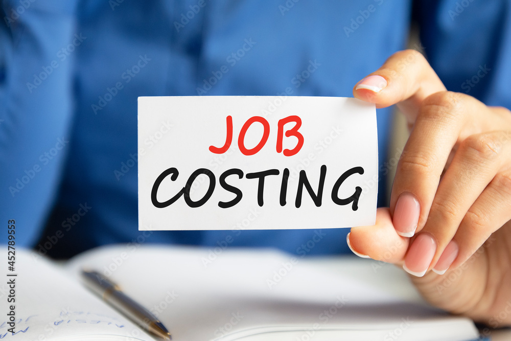 job costing written on a paper card in woman hand job costing written on a paper card in woman hand
