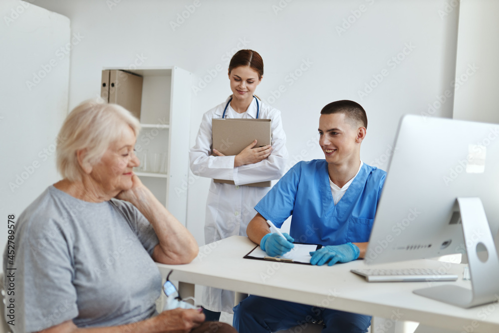 an elderly woman at a doctor's appointment and an assistant's sister communication treatment