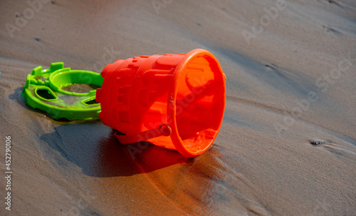 Children's toys on the warm sand of the beach of a wild lake in Quebec, Canada