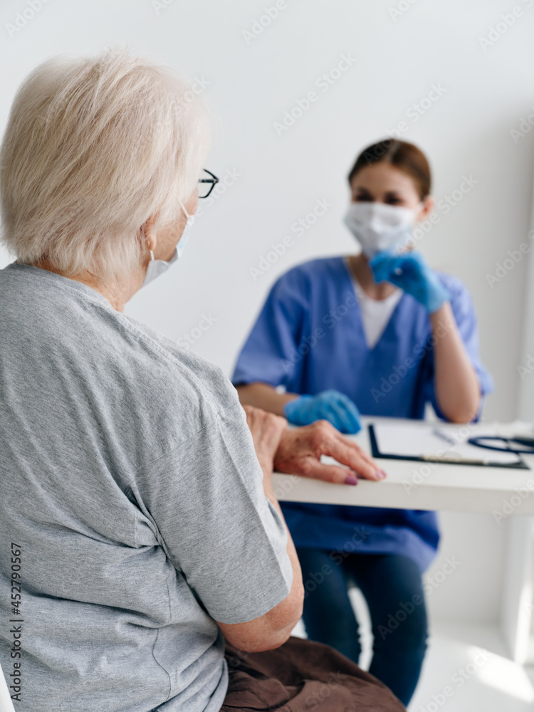 Obraz premium vaccine passport elderly woman in hospital communicates with doctor health immunity
