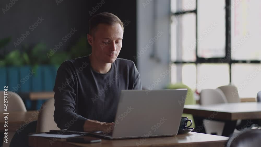 beautiful male developer or student working, studying by laptop in cafe. freelance, remote work, online education, self employed beautiful male developer or student working, studying by laptop in cafe. freelance, remote work, online education, self employed
