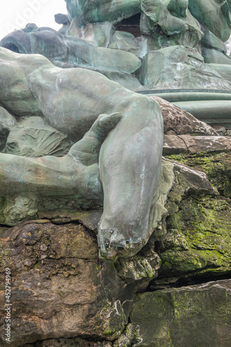 Antwerpen, Belgium - August 1, 2021: Green bronze Brabo statue on Grote Markt. Closeup of detail: the hand-less arm of giant Antigoon.