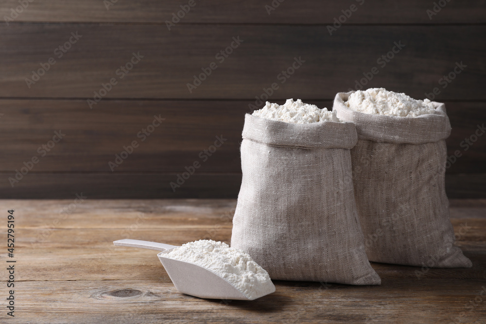 Sacks with flour on wooden background. Space for text Sacks with flour on wooden background. Space for text