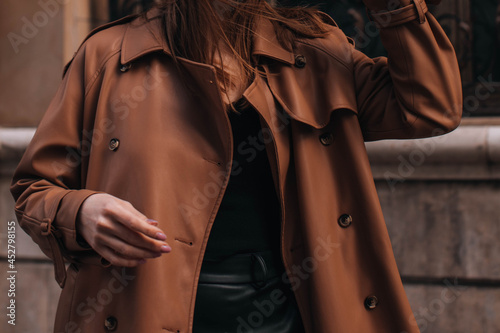 Stylish brown autumn fashionable coat on a female figure. Street fashion details photo