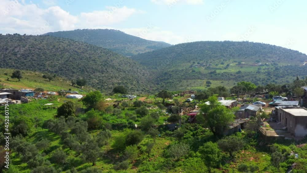 Aerial Scenic Shot Of Houses On Green Mountains Against Cloudy Sky During Sunny Day - North District, Israel Aerial Scenic Shot Of Houses On Green Mountains Against Cloudy Sky During Sunny Day - North District, Israel