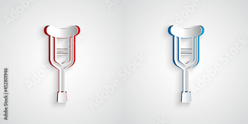 Paper cut Crutch or crutches icon isolated on grey background. Equipment for rehabilitation of people with diseases of musculoskeletal system. Paper art style. Vector