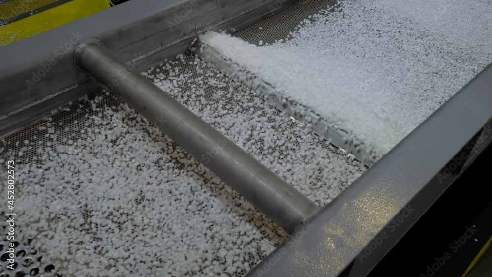 Propylene or polyethylene pellets - recycled plastic granules on conveyor belt, shale shaker of waste plastic recycling machine. Environmental protection, automated technology, separation concept