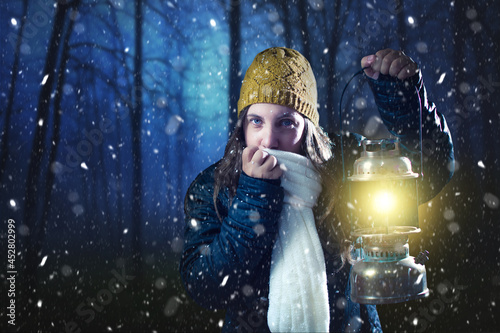 Woman in the forest at night with a lantern