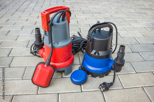 Two household submersible pump with plastic housings  on stone floor