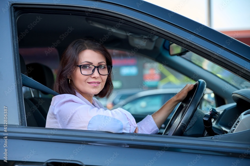 Middle-aged beautiful woman driver driving a car