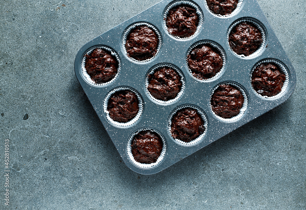 Raw chocolate muffins prepared for baking. Top view. Copy space Raw chocolate muffins prepared for baking. Top view. Copy space