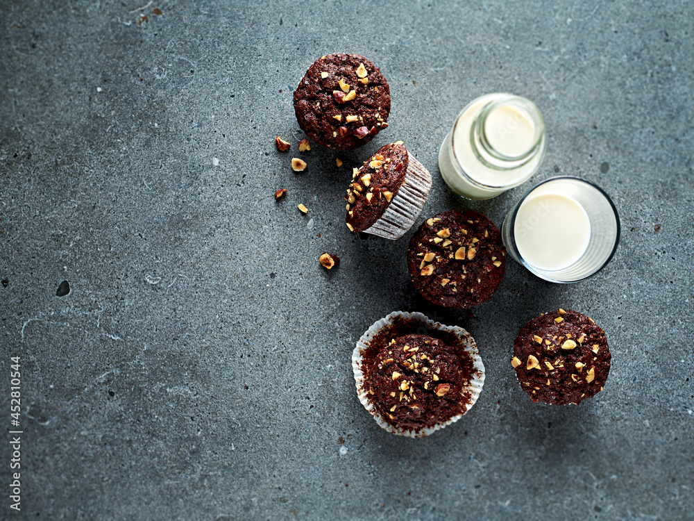 Chocolate muffins with hazelnuts and a glass of milk. Top view. Copy space Chocolate muffins with hazelnuts and a glass of milk. Top view. Copy space