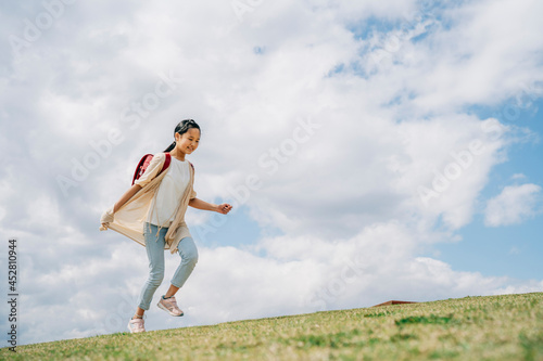 公園で走る小学生の女の子 