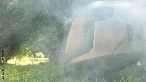 Smoke coming out on the black helmet of the motorycle on the grassy lawn in Estonia photo