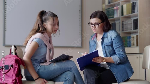 Woman school psychologist teacher talking and helping student, girl teenager