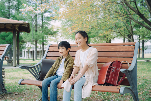 ベンチに座る小学生  © buritora