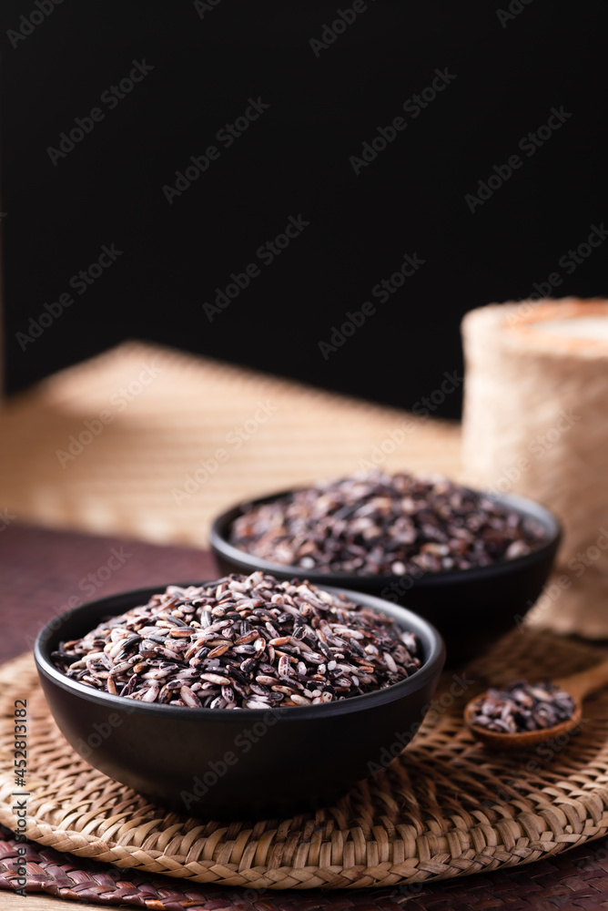 Purple glutinous rice grain in a black bowl, Thai rice Purple glutinous rice grain in a black bowl, Thai rice