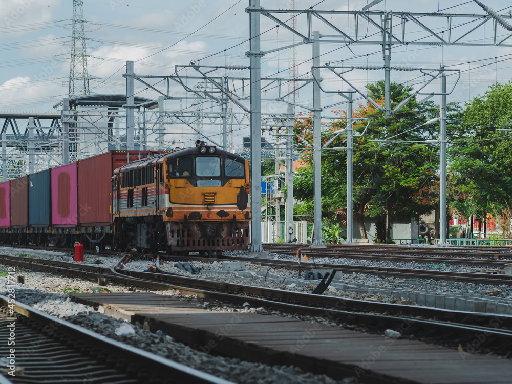 Freight Train with Cargo Containers at Bangkok Railway Station  is the main railway station in Bangkok and Railway station to across the country. background is building downtown.	
