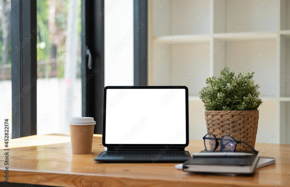 Shot of digital tablet with blank white screen, keyboard, cup of coffee on workspace desk Shot of digital tablet with blank white screen, keyboard, cup of coffee on workspace desk