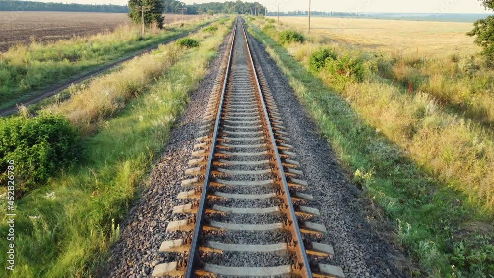 Straight railway tracks, train road through fields and forests