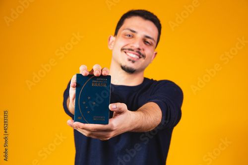 Portrait of a boy holding a Brazilian passport in his hands. Travel and migration concept photo