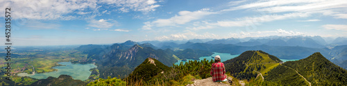 Woman sitting and relaxing at top of Mountain Herzogstand after hiking. looking at the spectacular bavarian Prealps mountains panorama with Lakes (Kochelsee, Walchensee) Europe, Germany © ImageSine