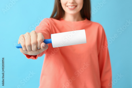 Young woman with lint rolle...
