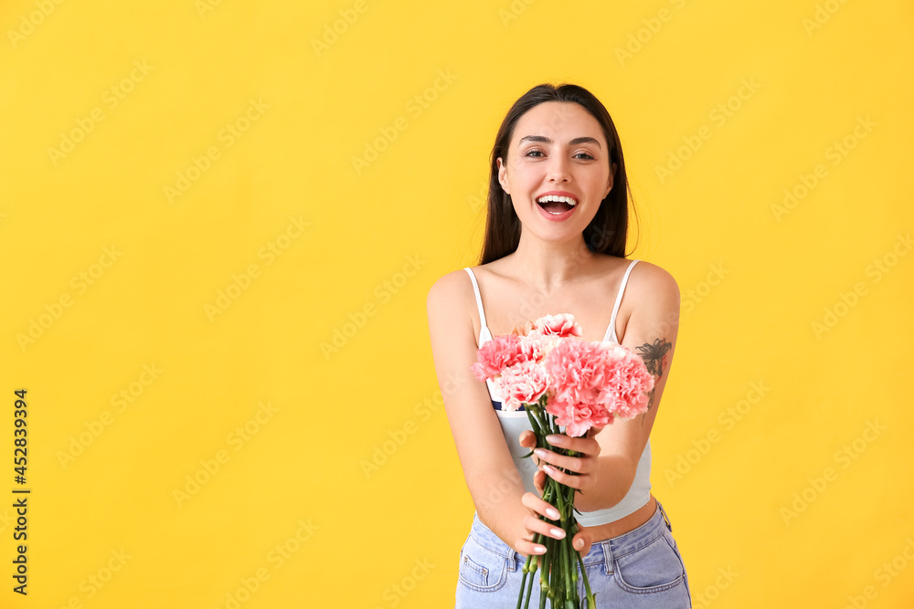 Young woman with beautiful carnation flowers on color background Young woman with beautiful carnation flowers on color background