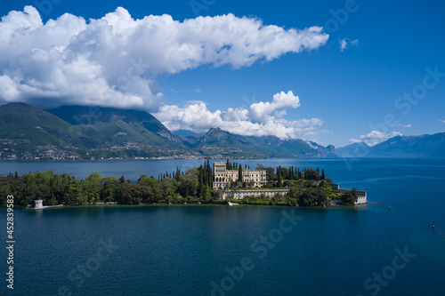Magnificent aerial panorama of Isola del Garda, Lake Garda, Italy. Castle on an island in Italy. Historic sites on Lake Garda. Isola del Garda, Italy. An island surrounded by the Italian Alps.