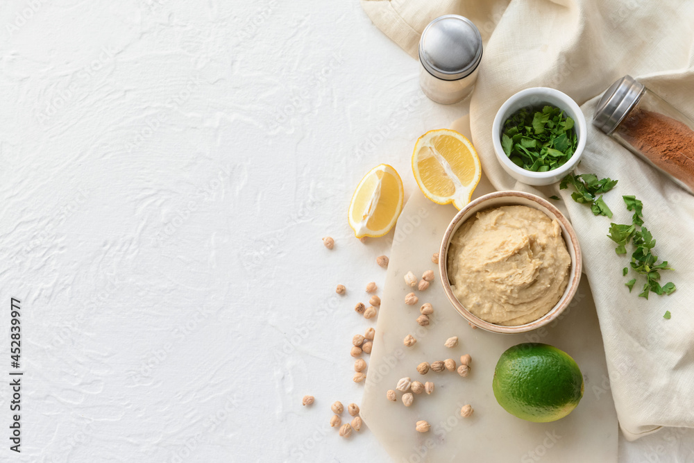Composition with tasty hummus and ingredients on light background Composition with tasty hummus and ingredients on light background