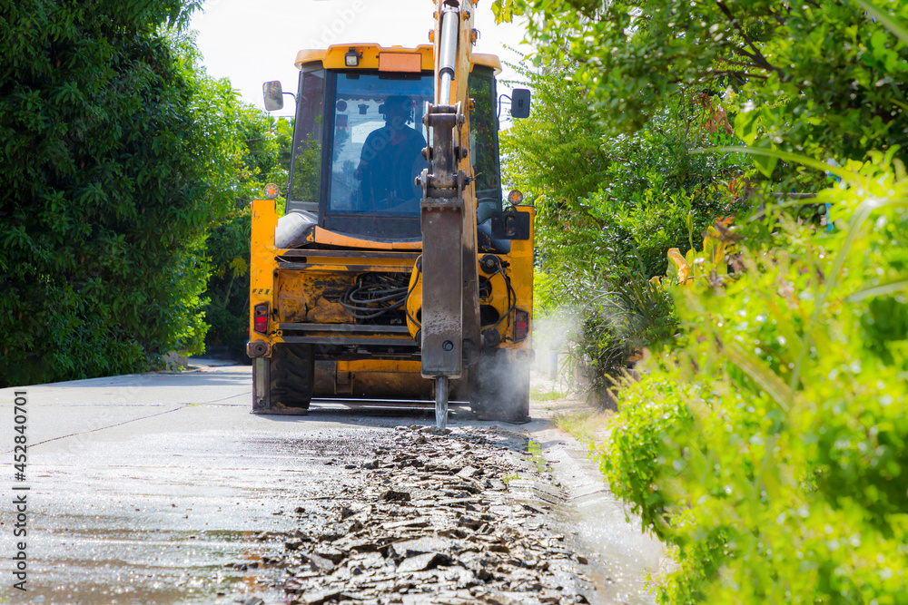 Reblocking Excavator breaking and drilling the concrete road for repairing. Large ...