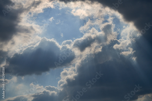 dramatic clouds float across the blue sky