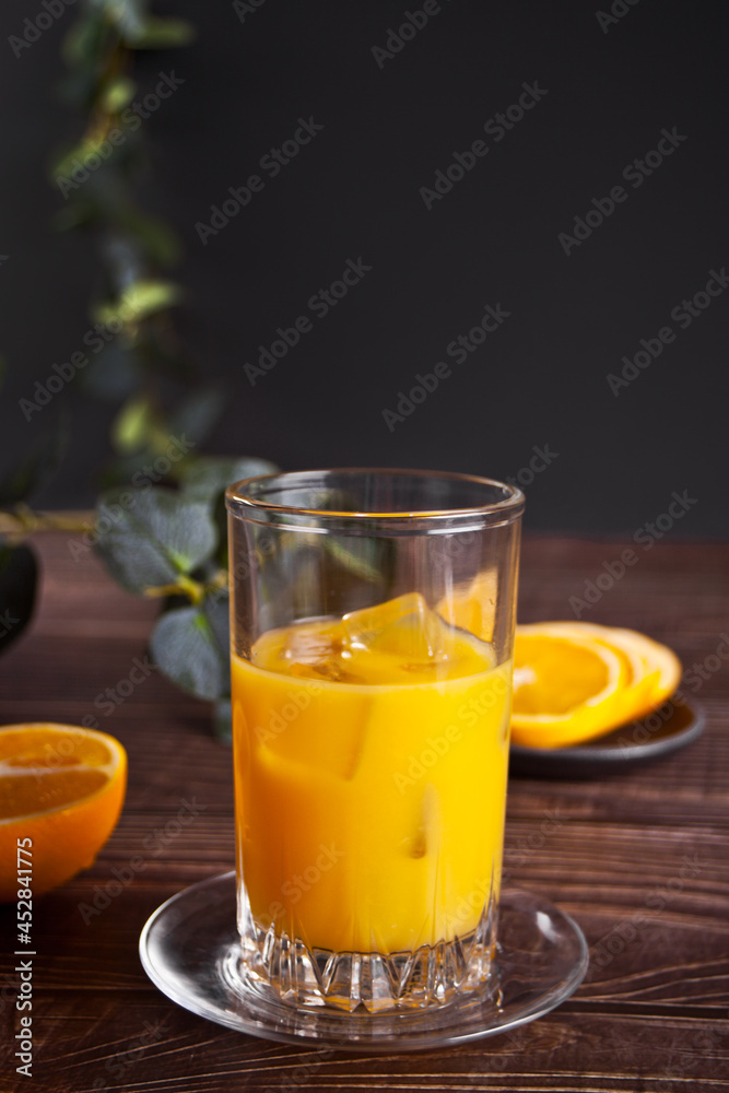 Fresh orange glass of juice with ice and oranges on rustic wood background. Fresh orange glass of juice with ice and oranges on rustic wood background.