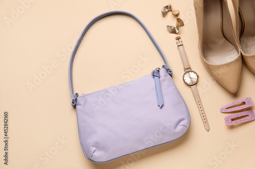 Composition with trendy handbag and accessories on color background