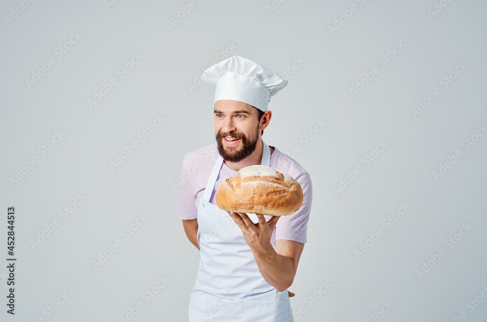 a man in a chef's uniform with bread in his hands preparing food for professionals
