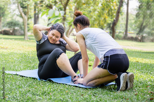Young woman and friend exercising in the park, healthy and lifestyle concepts