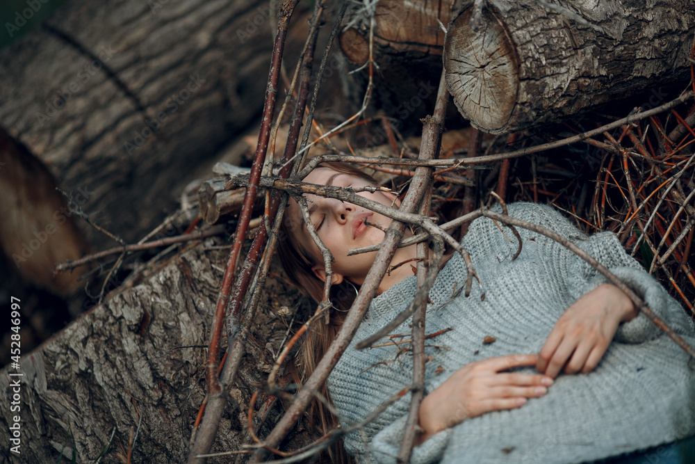 Teenager young woman lying outdoor in the park under dry tree ...
