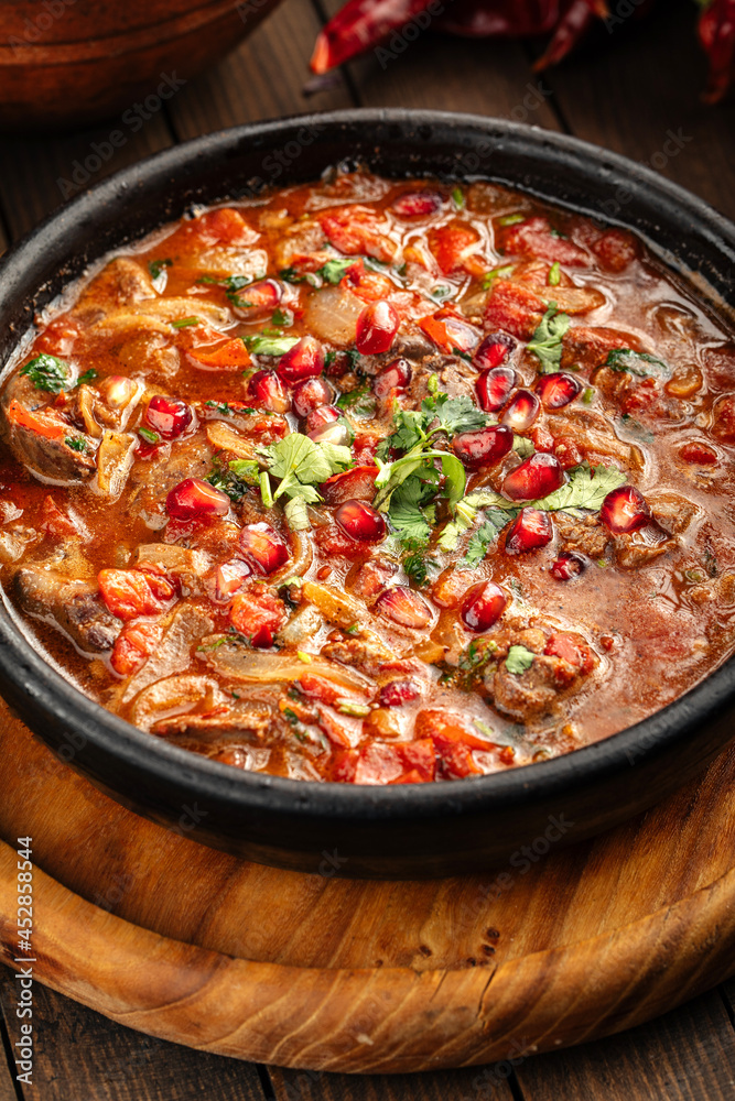 Top view on georgian chicken liver in tomato sauce with pomegranate Top view on georgian chicken liver in tomato sauce with pomegranate