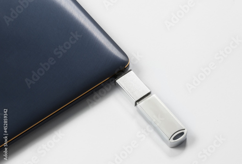 Portable USB flash drive connected to notebook isolated on white background. Mockup. High quality photo