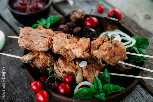 Fotografi Pork shashlik on pita bread with vegetables close-up