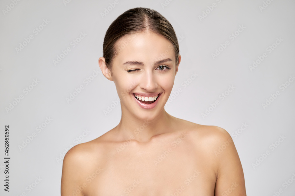 Beautiful Young Woman with Clean Fresh Skin standing over light grey background Beautiful Young Woman with Clean Fresh Skin standing over light grey background