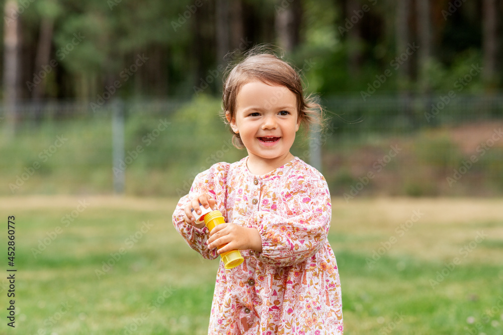 childhood, leisure and people concept - happy little baby girl with soap bubble blower in summer childhood, leisure and people concept - happy little baby girl with soap bubble blower in summer