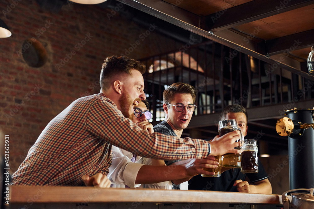 Obraz premium Positive friends. People in casual clothes sitting in the pub