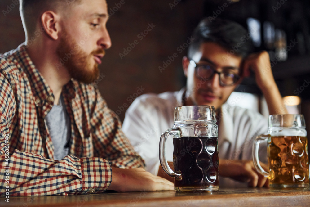People in casual clothes sitting in the pub and having conversation People in casual clothes sitting in the pub and having conversation