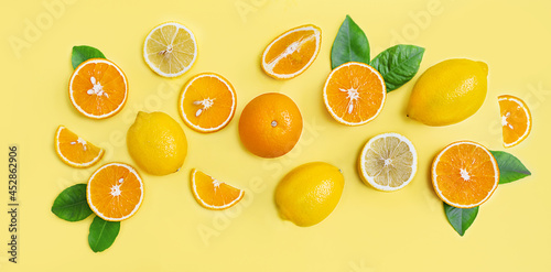 Composition of citrus lemons and oranges on a yellow background